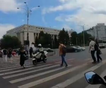 Momentul în care un poliţist pe motocicletă loveşte în plin o femeie aflată ...